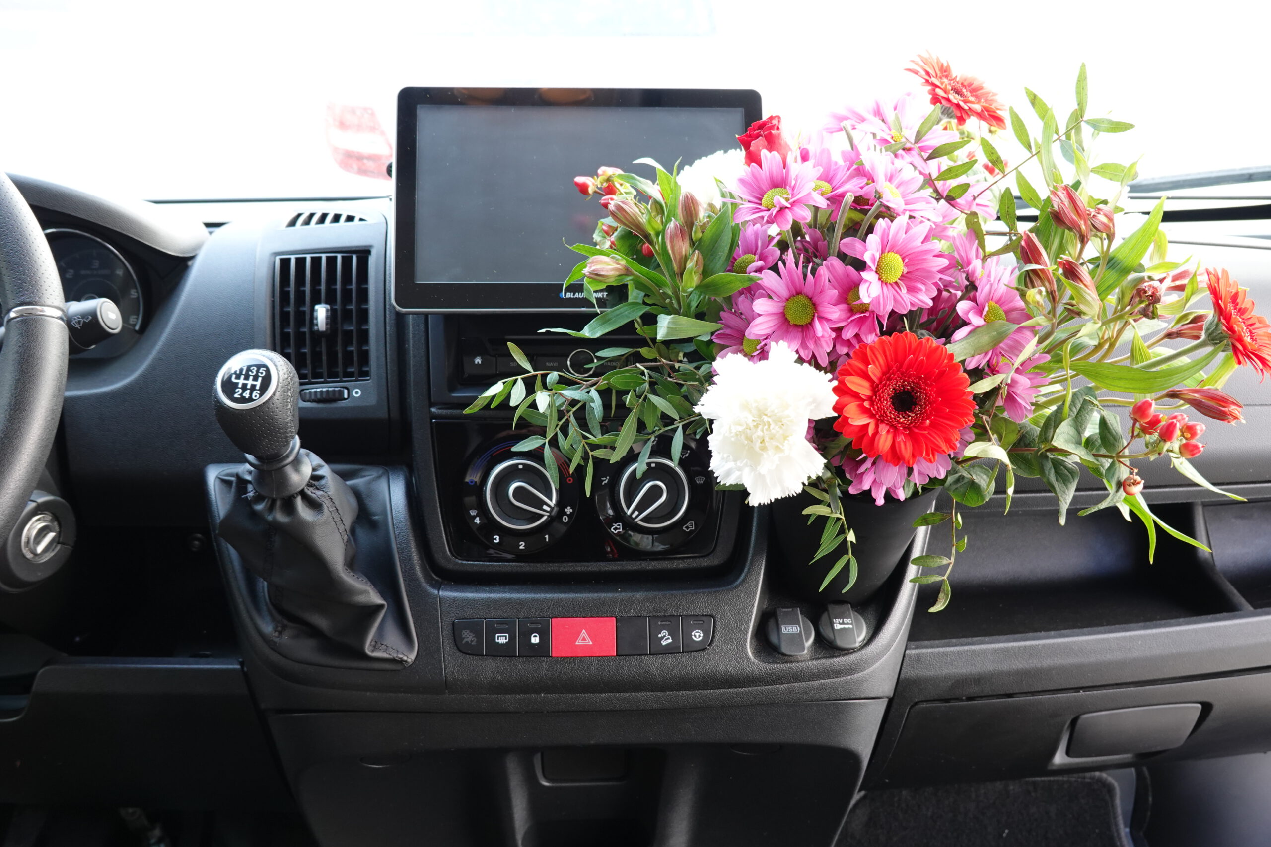 Camperflower Camper Blumentopf im Cockpit eines Fiat Ducato Kastenwagen Camper mit einem Blumenstrauß